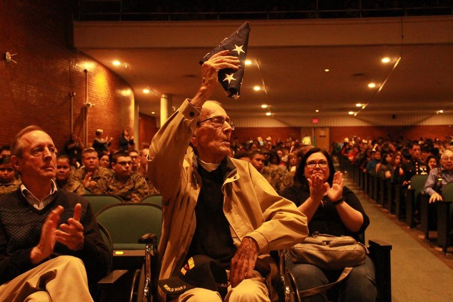 Oldest Veteran attendee, William Crawford holding up flag, that he received, during the National Anthem.