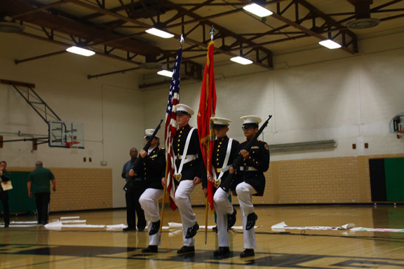 The ROTC marches out to present the flags at a pep assembly before a big game.