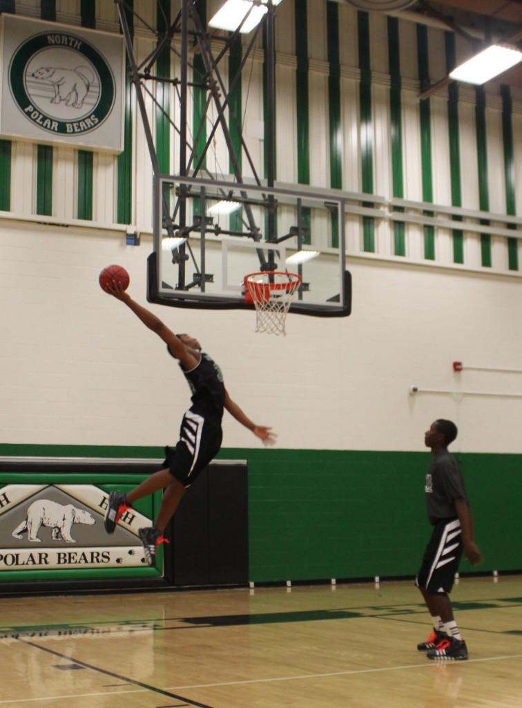#34 of the North High Boys Basketball team, Samuel Williams Jr practice his dunking in a photo shoot with the Oracle.