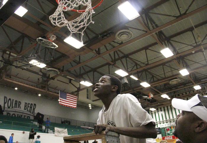Senior Sekou Mtayari climbs the ladder to cut a piece of the net following the 71-61 victory over Hoover to clinch the Metro Conference title. Mtayari averages 5.1 points per game for the Polar Bears.