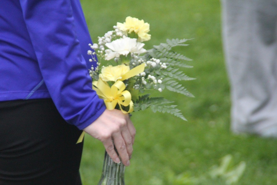 A young female waits patiently to place her flowers next to the memorial of Kendall Foster.