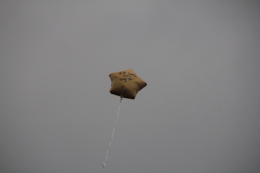 A loose balloon drifts off into the sky as other balloons were released in memory for Kendall Foster.