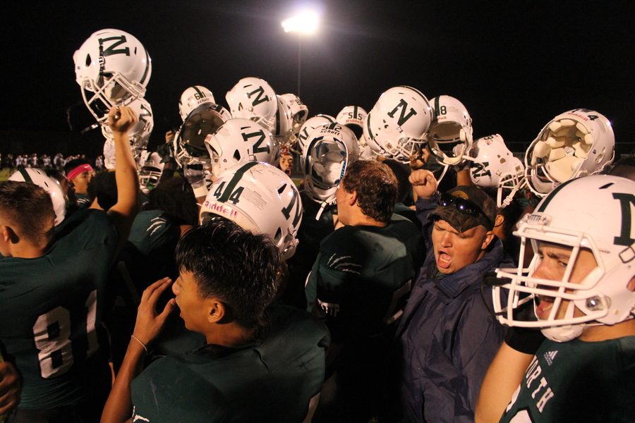The team holds up their helmets after the big win Friday, August 26, 2016 against Waterloo East Trojans.
