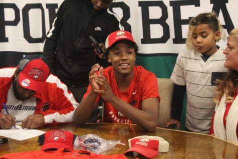 Tyreke Locure sports Panthers gear as he prepares to sign his commitment to play basketball for the University of Southern Alabama.